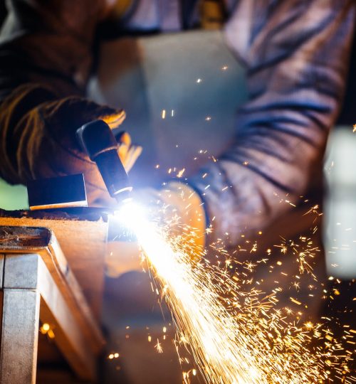 Worker cutting metal with plasma equipment on plant.
